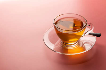 A cup of freshly brewed hot tea in a glass on the pink background with copy spaceの写真素材