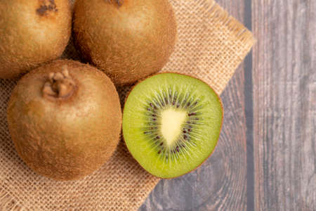 A half of fresh green kiwi in a wood bowlの写真素材