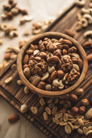 Different types of nuts, nut mix of almonds, hazelnuts, cashews, peanuts in a wooden bowl. Close up