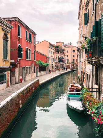 Beautiful bright streets of Italy, with water channels between houses, boats, canoes. Travel photo.の写真素材
