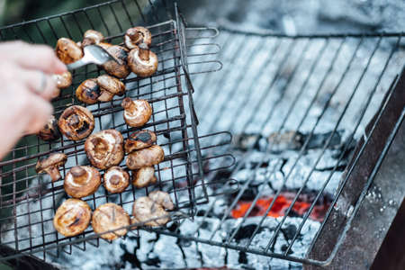 Grilled mushrooms. BBQ grill and burning coals, cooking outdoors. Copy space.の写真素材