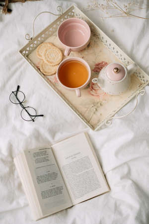 Kettle with tea and cups on a tray. Breakfast at home in bed, comfort and coziness. High quality photoの写真素材
