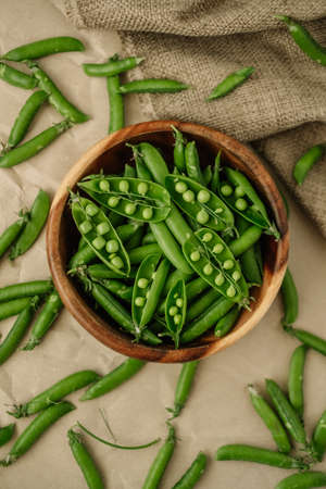 Green fresh peas in a wooden bowl. Healthy food. High quality photoの写真素材
