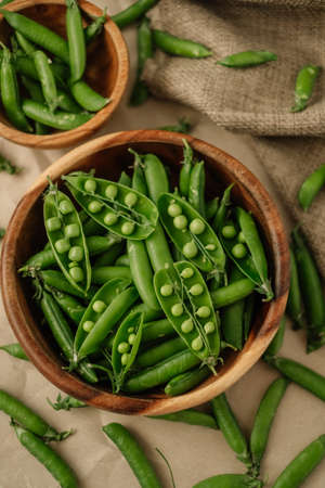 Green fresh peas in a wooden bowl. Healthy food. High quality photoの写真素材