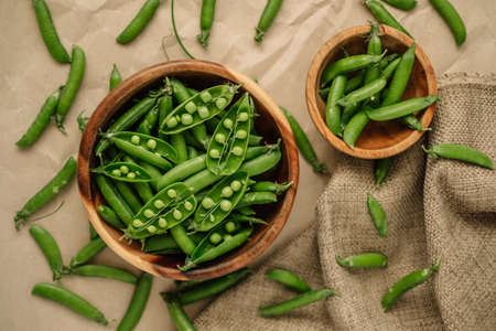 Green fresh peas in a wooden bowl. Healthy food. High quality photoの写真素材