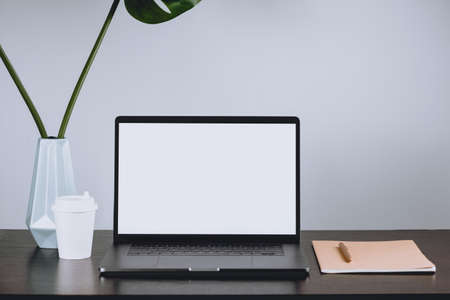 Workplace, notebook with pen, glass of coffee and flower decoration.