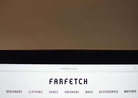 Farfetch online fashion store. Laptop with screen of farfetch site.のeditorial素材