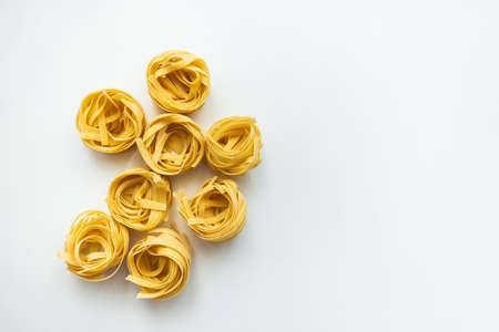 Italian wheat pasta tagliatelle isolated on white background. Top view, close-up.の写真素材