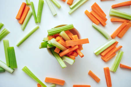 Sliced carrots and celery in a white bowl, healthy food, recipe background. High quality photoの写真素材