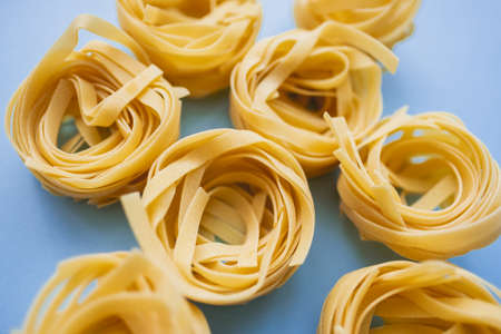 Italian wheat pasta tagliatelle isolated on white background. Top view, close-up.の写真素材