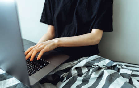 Programmer Girl working on laptop computer in home with copyspace.の写真素材