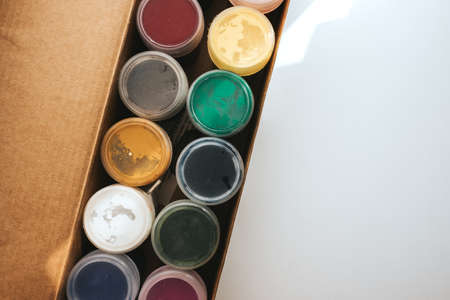 Gouache paints in a cardboard box on a white background. Different colors.の写真素材