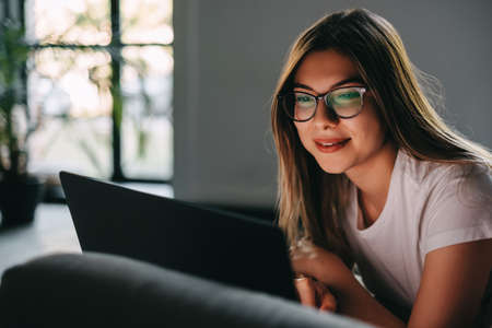 Young smiling caucasian woman standing near the window in business hall, taking notes in a notepad. High quality photoの写真素材