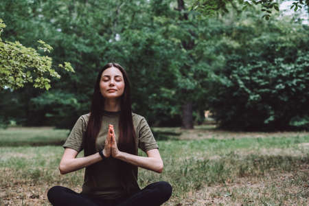 Young happy caucasian woman meditating alone in nature. Healthy lifestyle and relaxations. High quality photoの写真素材