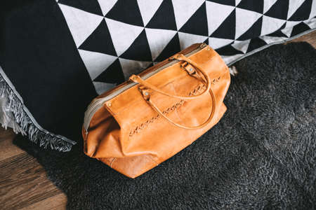 Leather travel bag near the bed in the living room. travel preparation, weekend concept. High quality photoの写真素材