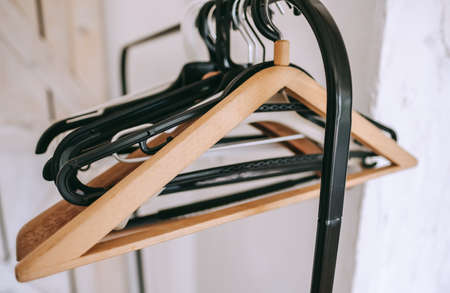 Black metal clothing rail with empty coat hangers in a white room.の写真素材