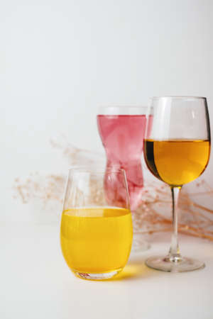 Glasses with multi-colored drinks on a white background.の写真素材