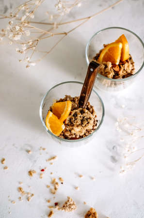 Natural yogurt and granola with slices of fruits and nuts in a glass cup, healthy breakfastの写真素材