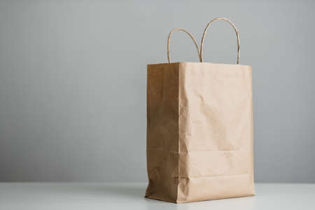 Craft eco pack on white table, gray background, mock up. Delivery concept. High quality photoの写真素材