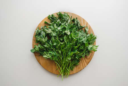 Green parsley on a wooden board, white background. Proper nutrition. Flat lay. High quality photoの写真素材