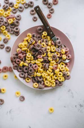 Multi-colored corn rings on a pink plate for breakfast, healthy food. High quality photoの写真素材