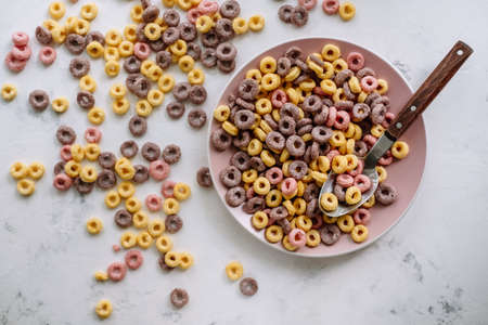 Multi-colored corn rings on a pink plate for breakfast, healthy food. High quality photoの写真素材
