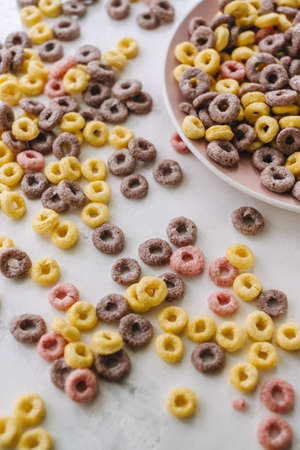 Multi-colored corn rings on a pink plate for breakfast, healthy food. High quality photoの写真素材