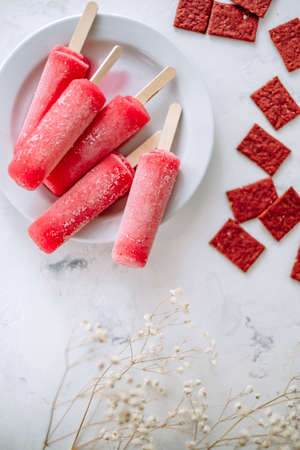 Pink fruit ice sorbet close-up on a white plate. Stick ice cream. High quality photoの写真素材
