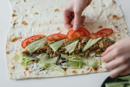 Cooking chicken roll with meat, fresh vegetables, herbs and sauce. High quality photoの写真素材