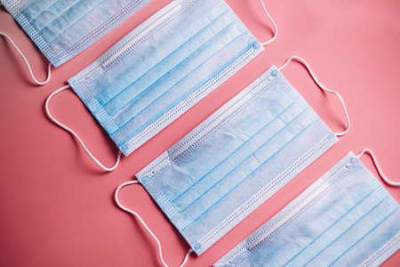 Group of medical protective masks in isolated on pink background. Medical mask protection against pollution, virus, flu, coughing and coronavirus. High quality photoの写真素材