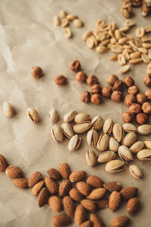 Different types of nuts, nut mix of almonds, hazelnuts, cashews, peanuts on a craft paper. High quality photoの写真素材