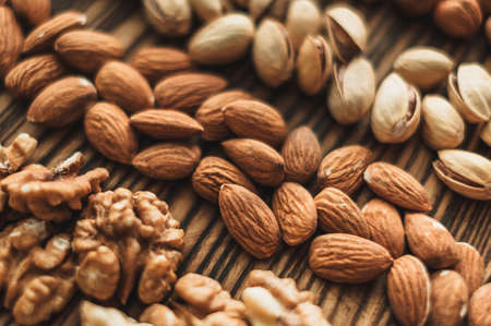Different types of nuts, nut mix of almonds, hazelnuts, cashews, peanuts on a wooden board. High quality photoの写真素材