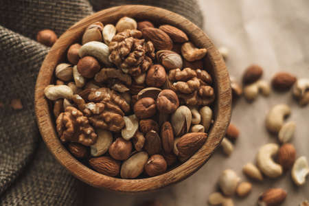 Different types of nuts, nut mix of almonds, hazelnuts, cashews, peanuts in a wooden bowl. Close up. High quality photoの写真素材