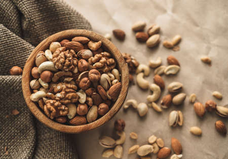 Different types of nuts, nut mix of almonds, hazelnuts, cashews, peanuts in a wooden bowl. Close up. High quality photoの写真素材