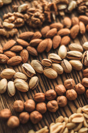 Different types of nuts, nut mix of almonds, hazelnuts, cashews, peanuts on a wooden board. High quality photoの写真素材