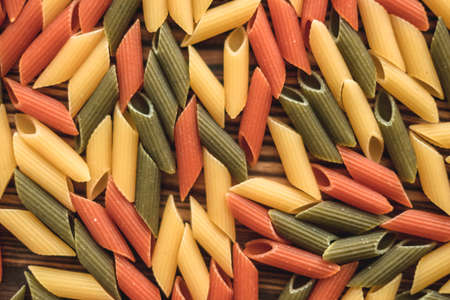 Colored Italian wheat pasta on a wooden board. Healthy food. High quality photoの写真素材