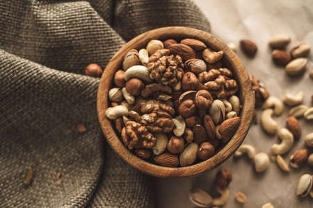 Different types of nuts, nut mix of almonds, hazelnuts, cashews, peanuts in a wooden bowl. Close up. High quality photoの写真素材