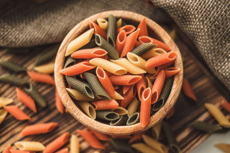 Colored Italian wheat pasta in a wooden bowl. Healthy food. ... High quality photoの写真素材