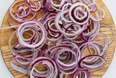 Red onion rings on a wooden board isolated on a white background. Close up. Cooking concept. High quality photoの写真素材