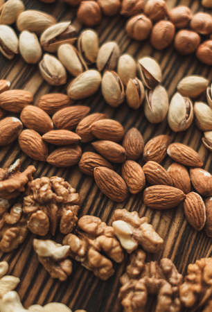 Different types of nuts, nut mix of almonds, hazelnuts, cashews, peanuts on a wooden board. High quality photoの写真素材