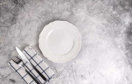 Empty white plate with cutlery on a gray background. Mock up. High quality photoの写真素材
