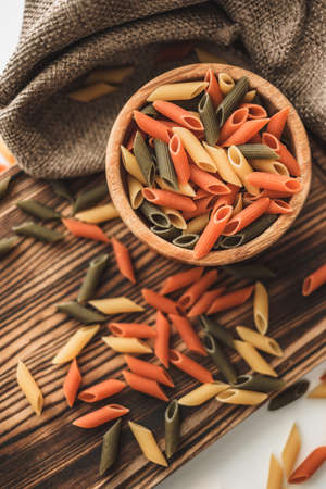 Colored Italian wheat pasta in a wooden bowl. Healthy food. ... High quality photoの写真素材