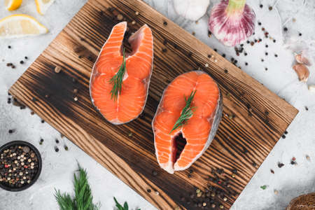 Fresh steaks of red salmon fish with spices and herbs on a wooden board. High quality photoの写真素材