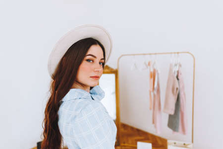 Successful fashion designer. Attractive young caucasian woman looking at camera with smile while standing in studio. Beautiful owner business woman working in fashion clothing studio.の写真素材