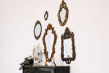 Antique old mirrors on a white wall indoor. Interior design. High quality photoの写真素材