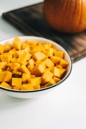 Close up view of fresh, vivid orange pumpkin pieces in a white plate. Healthy and nutritious food. High quality photoの写真素材