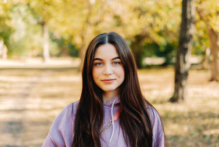 Portrait of beautiful young woman in the park. Woman walking in the autumn park. High quality photoの写真素材