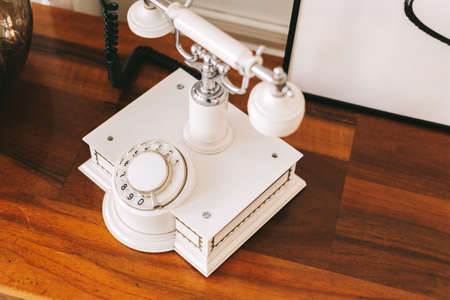 White retro telephone on a wooden table. Close-up. High quality photoの写真素材