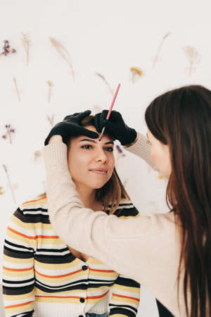 Eyebrow shaping procedure, make-up master uses brush to shape the eyebrows. High quality photoの写真素材