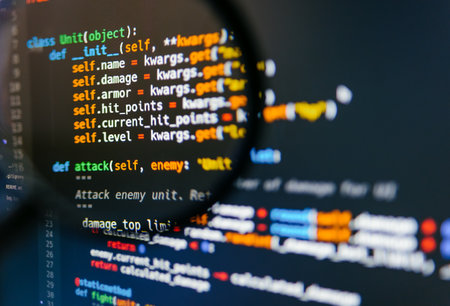 Program code on computer display in magnifying glass. Close-up. High quality photo